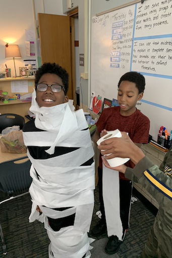 Students in class wrapped in paper