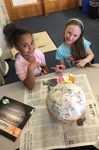 Two students posing with paint